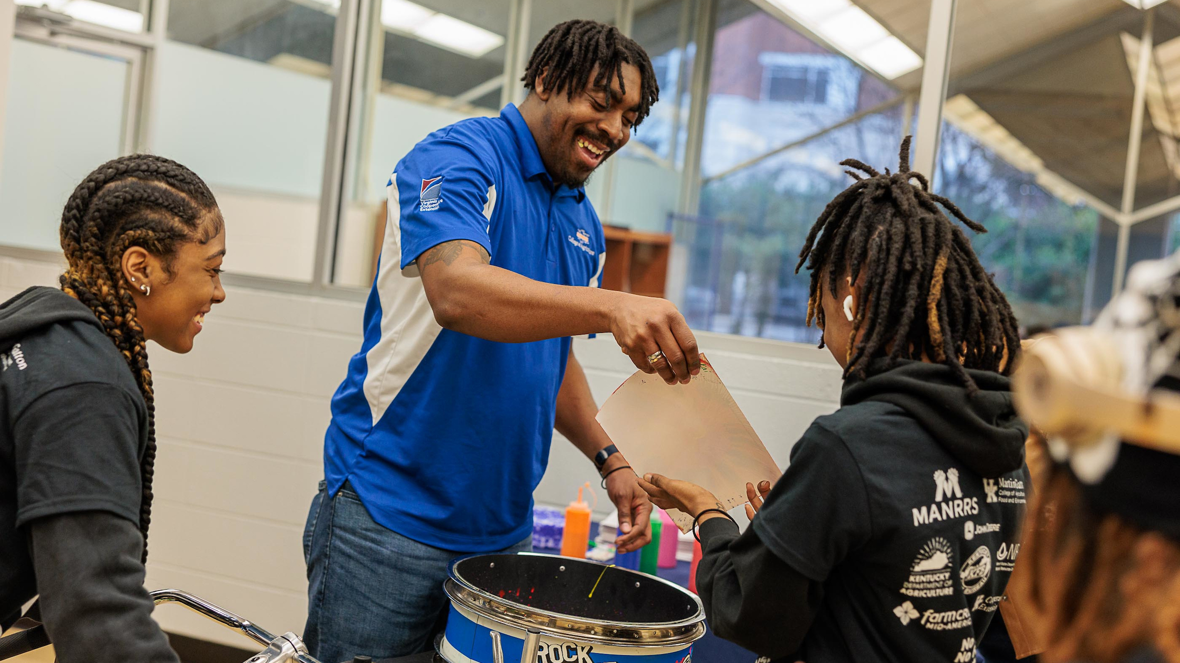 A teacher interacts with students during an activity